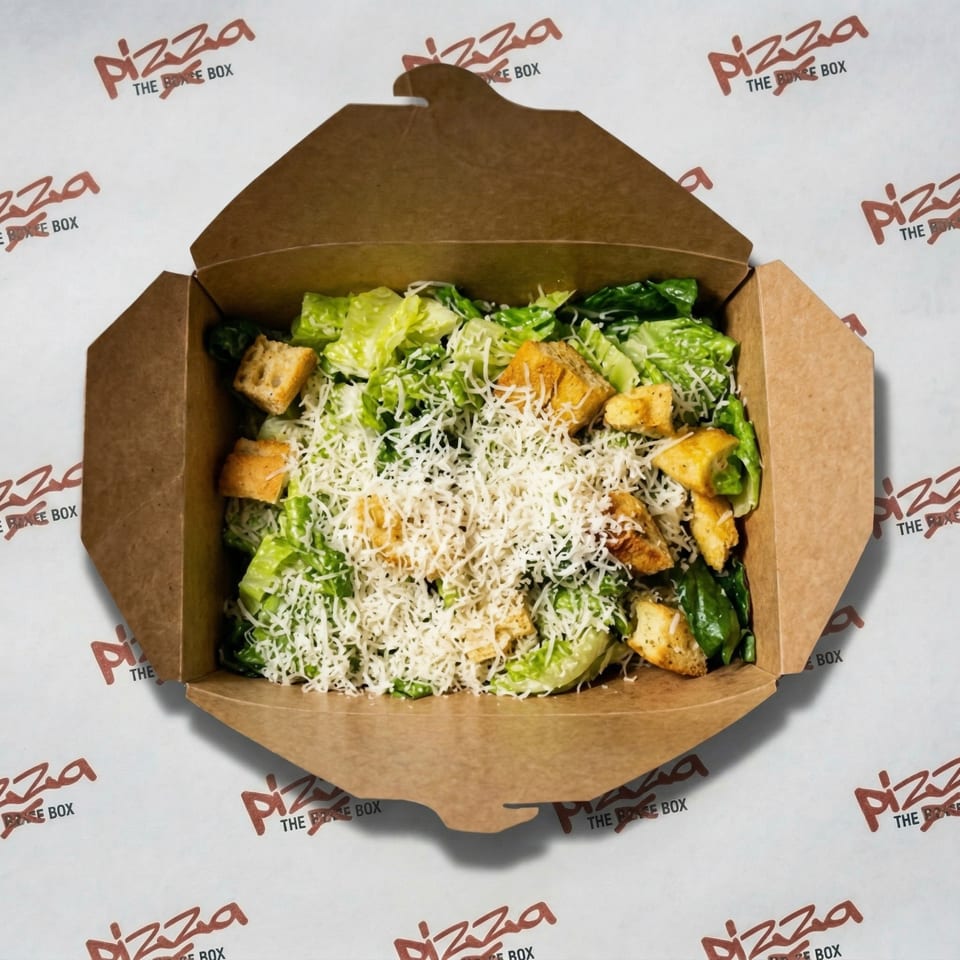 Caesar salad with croutons and shredded cheese in a brown takeout box from Pizza The Box.